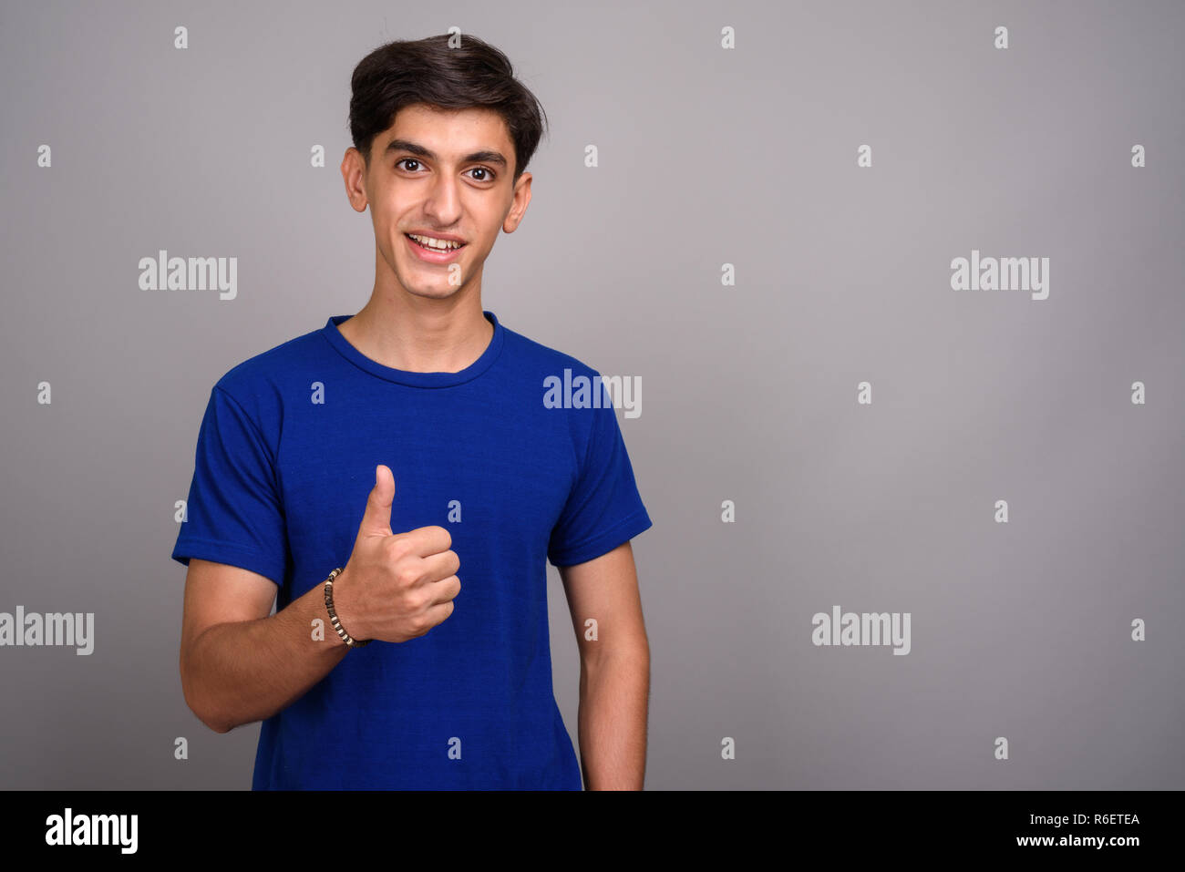 Young handsome Persian teenage boy giving thumb up Stock Photo