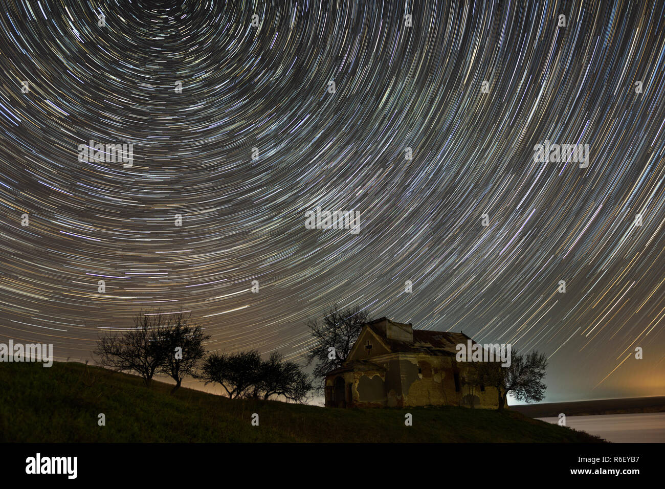 Star trails over an abandoned church in Romania Stock Photo