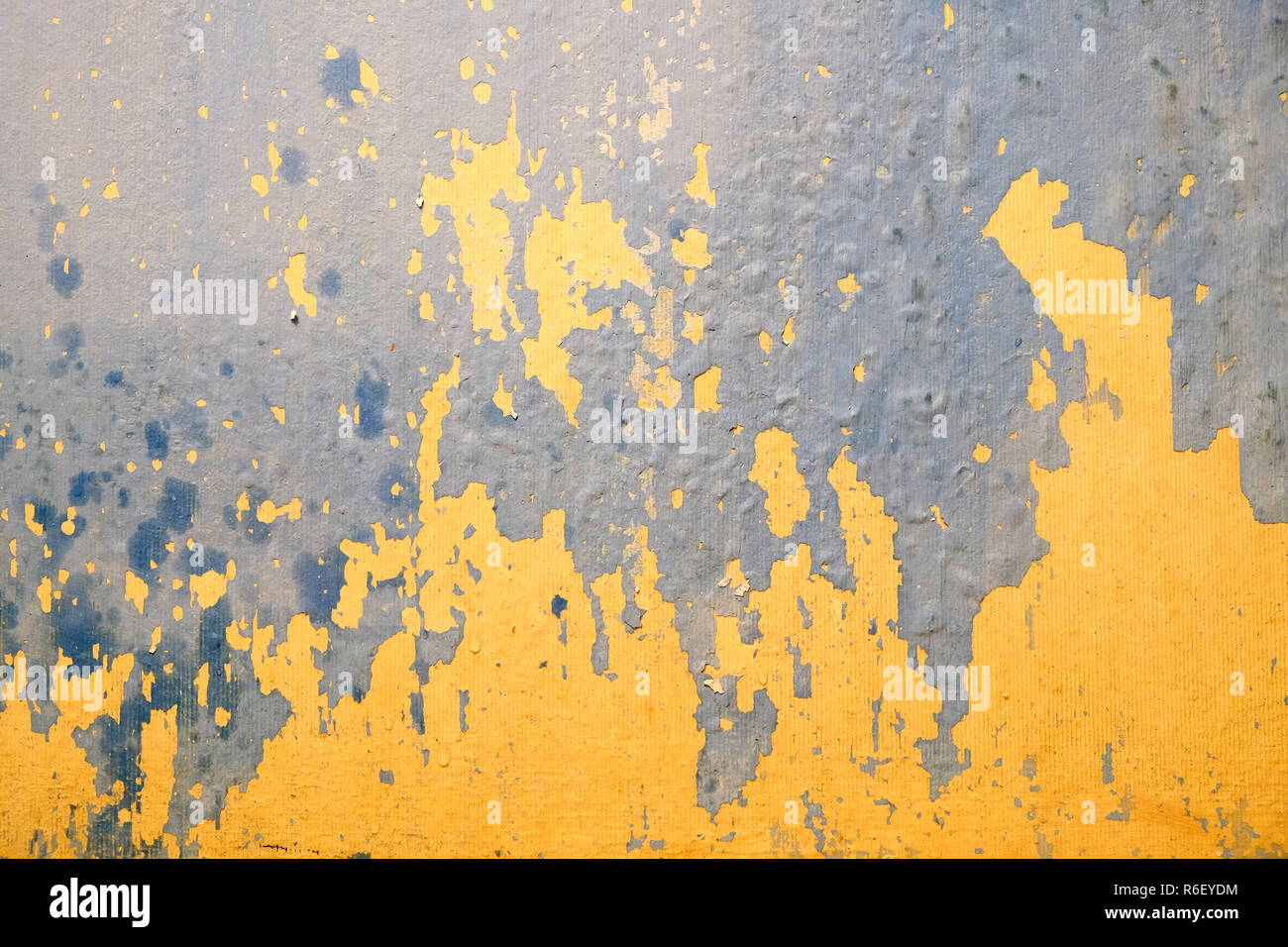 Wall in bad condition with old yellow and blue paint inside house in