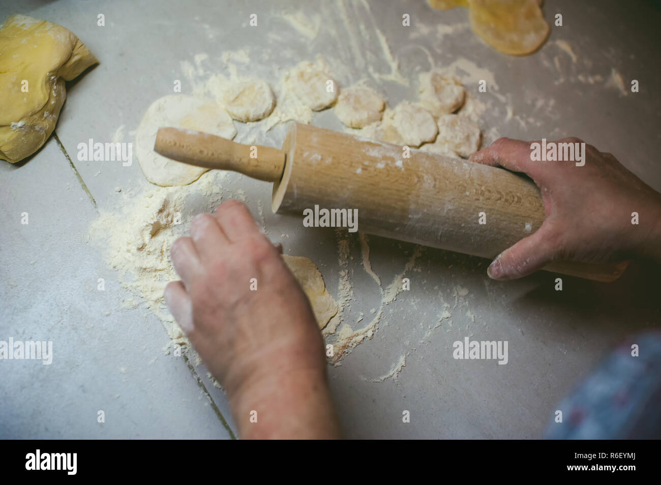hand modeling dumplings at home in the kitchen. rolling pin in hand ...