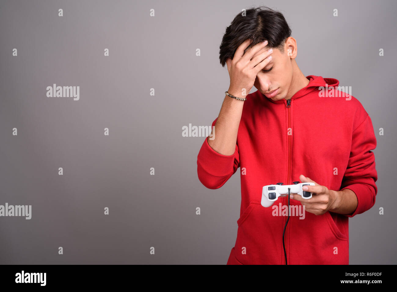 Persian teenage boy playing video games with game controller Stock Photo