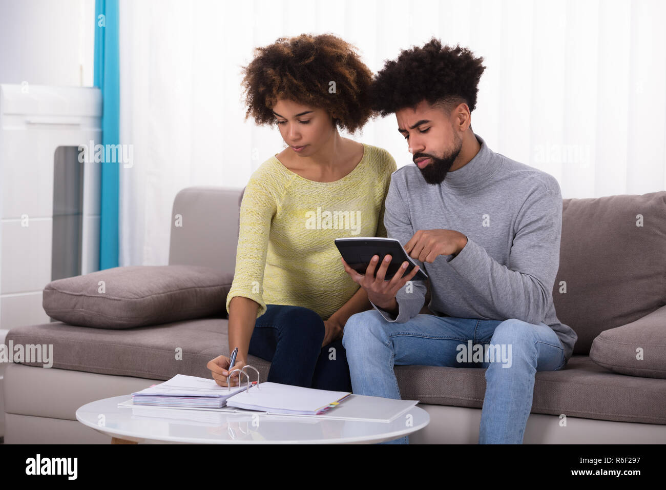 Couple Calculating Bill With Calculator Stock Photo Alamy