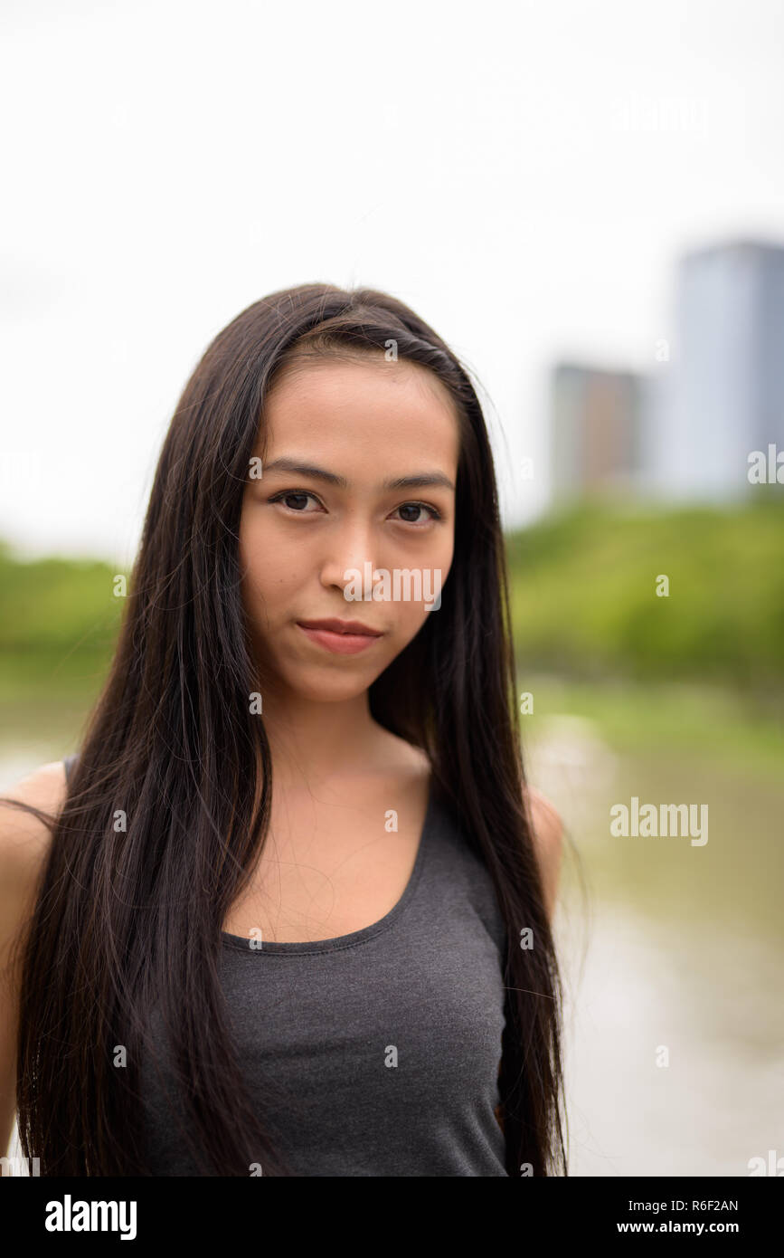 Young beautiful Asian woman relaxing at the park Stock Photo