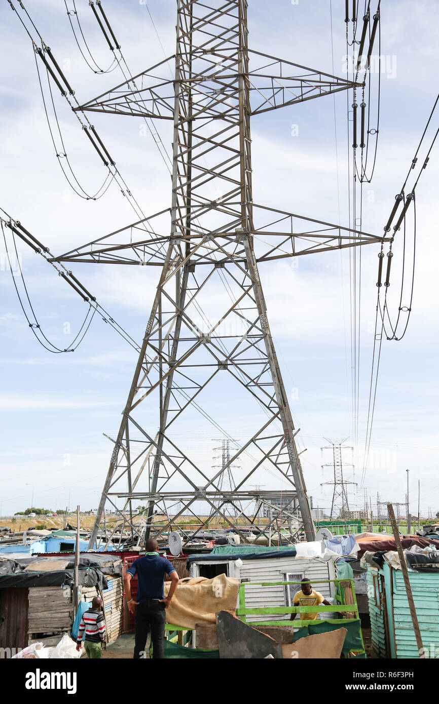 Cape Town South Africa 28th Dec 2013 A man walks to dwellings (shacks) under power lines in Cape towns Informal settlement. Stock Photo