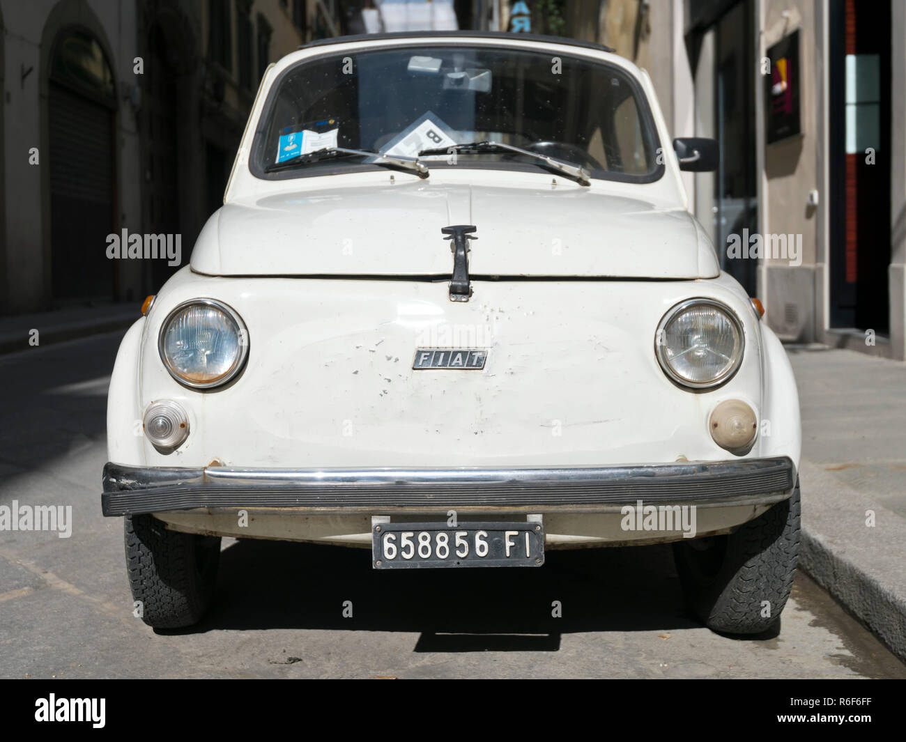Horizontal close up of a dilapidated old Fiat 500 parked in Italy. Stock Photo