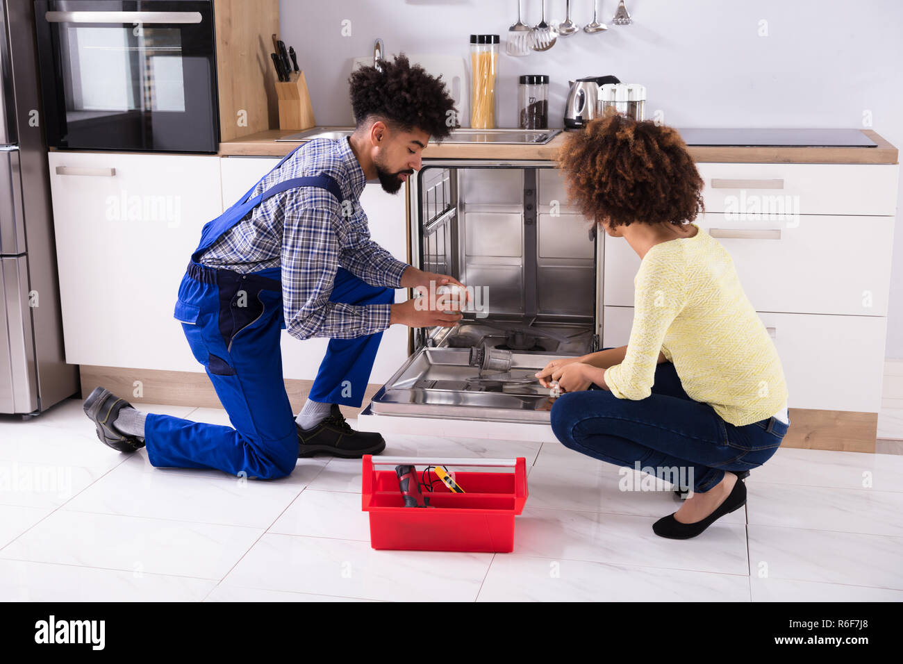 Repairman Fixing Dishwasher In Kitchen Stock Photo Alamy
