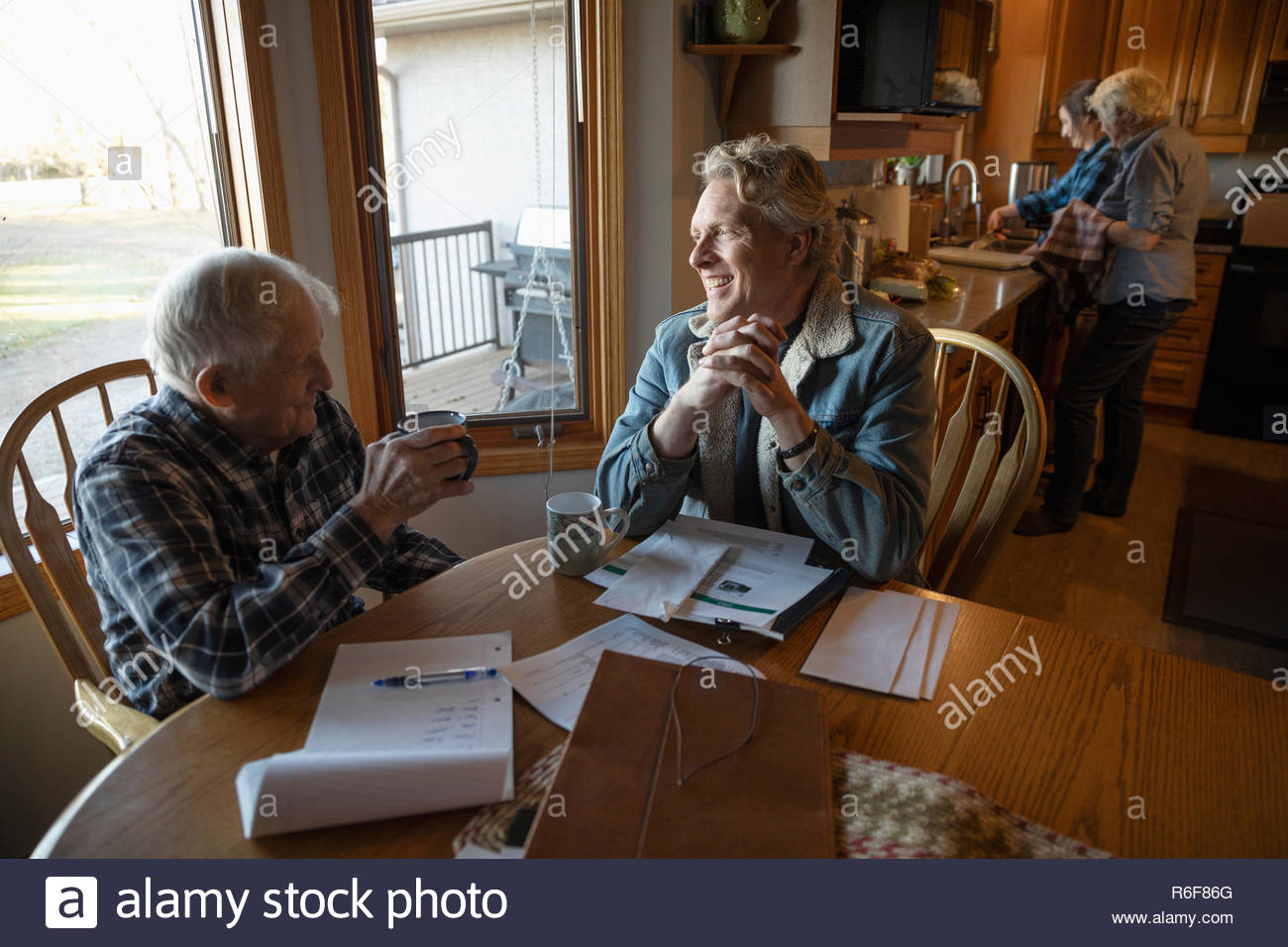 Farmers paying bills, talking at kitchen table Stock Photo - Alamy