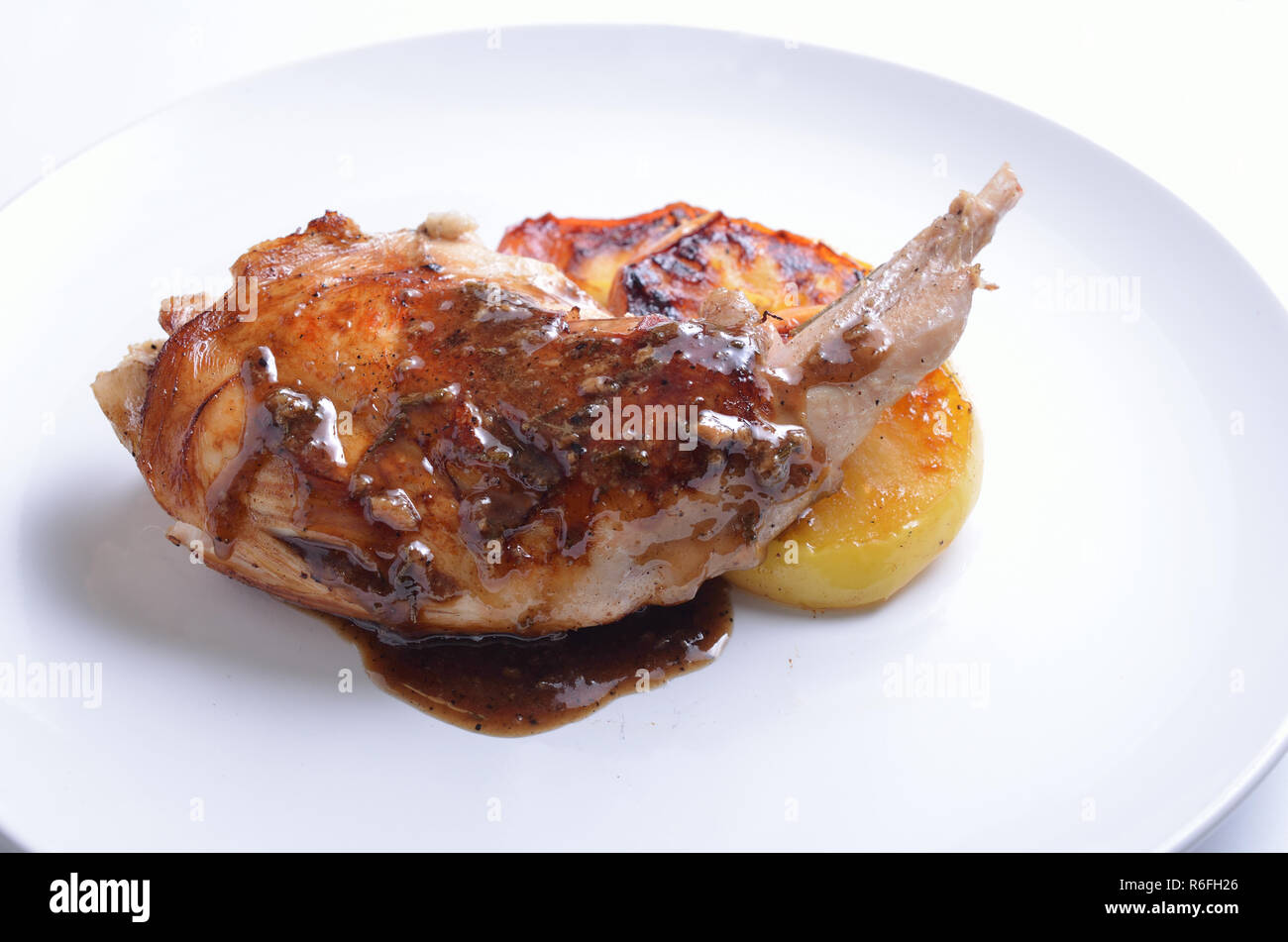 Sous Vide rabbit leg with sous and grilled apple on white plate Stock Photo  - Alamy