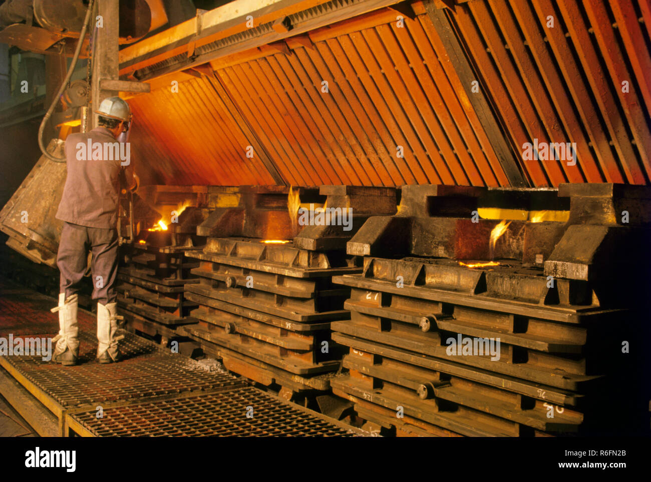 worker Pouring molten yellow steel in Molds Stock Photo