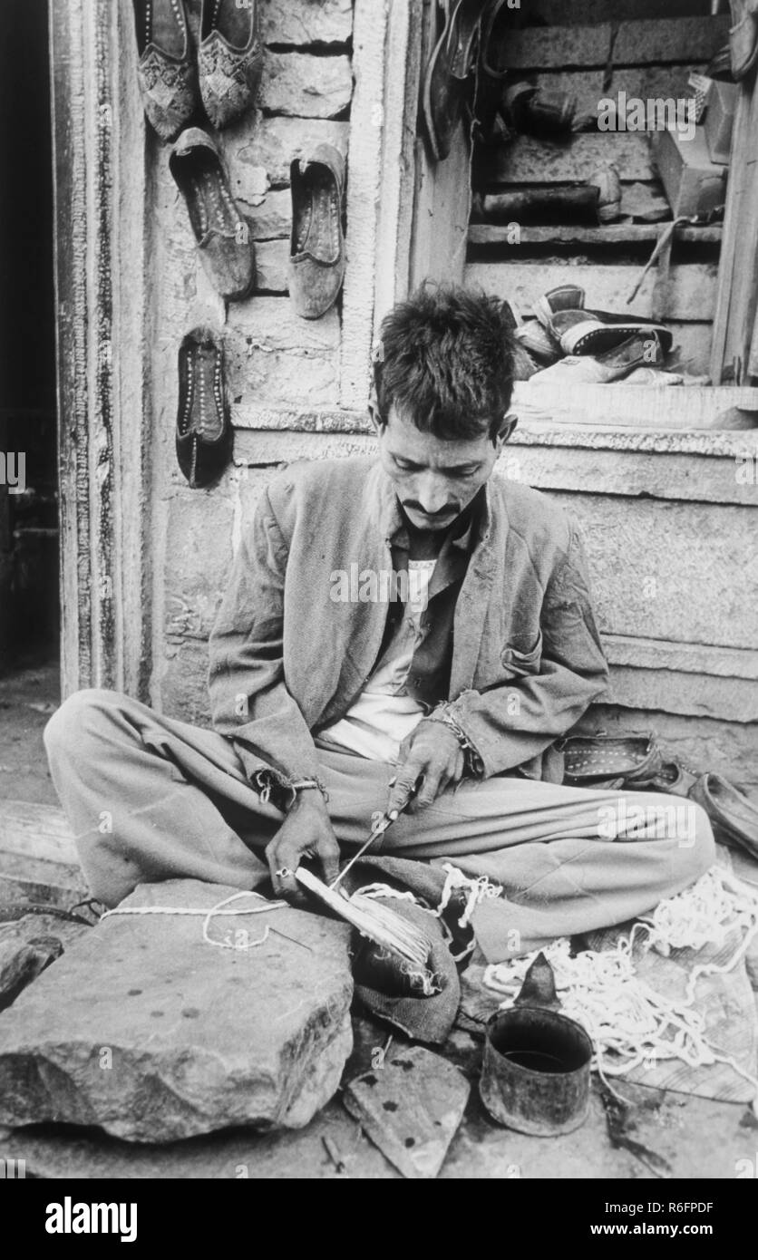 Cobbler, man repairing shoes, India, old vintage 1900s picture Stock Photo