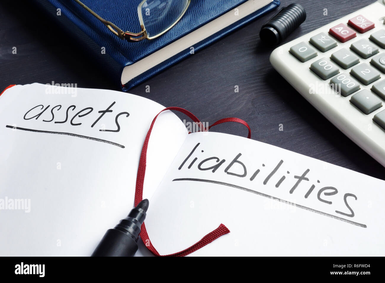 List of assets vs liabilities in the note pad. Stock Photo