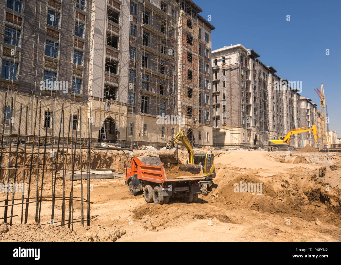 on the construction site, the excavator loads the land into the dump truck Stock Photo