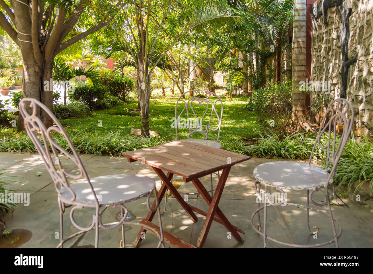 Sleeping corner with three iron chairs in a tropical garden in Nairobi