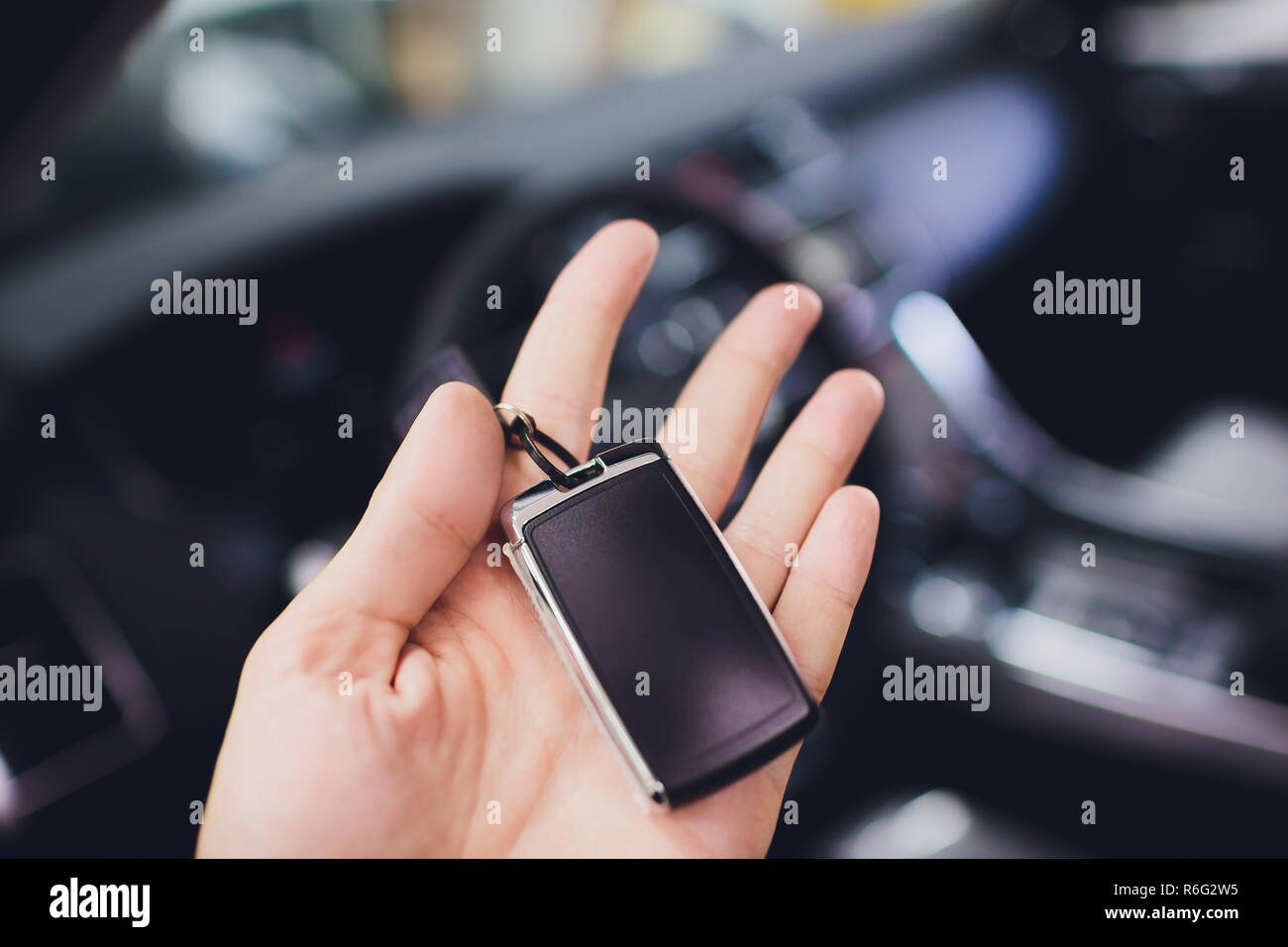 Man hand with car key on background salon new auto Stock Photo - Alamy
