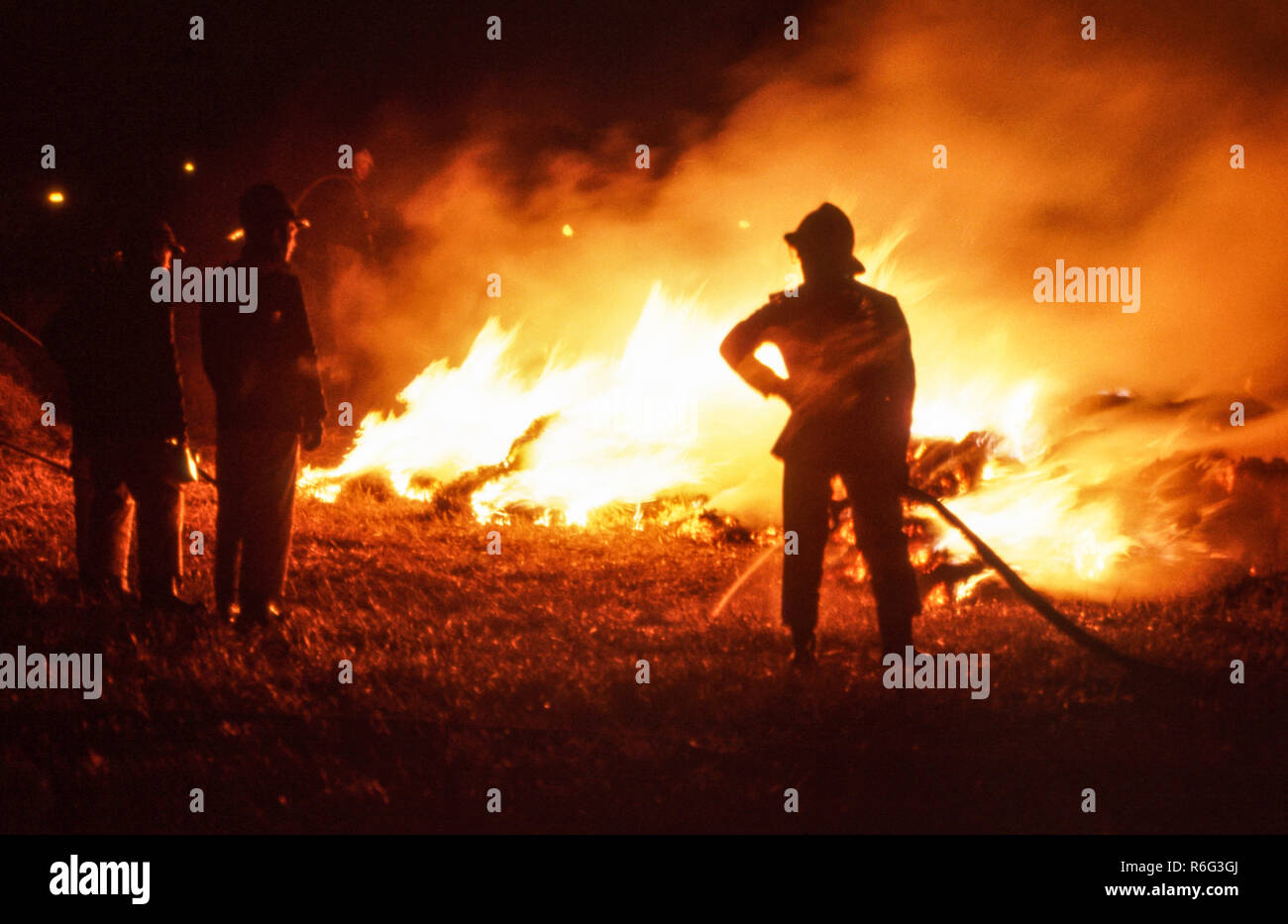 Firemen at a hayrick fire in northeast England. Stock Photo