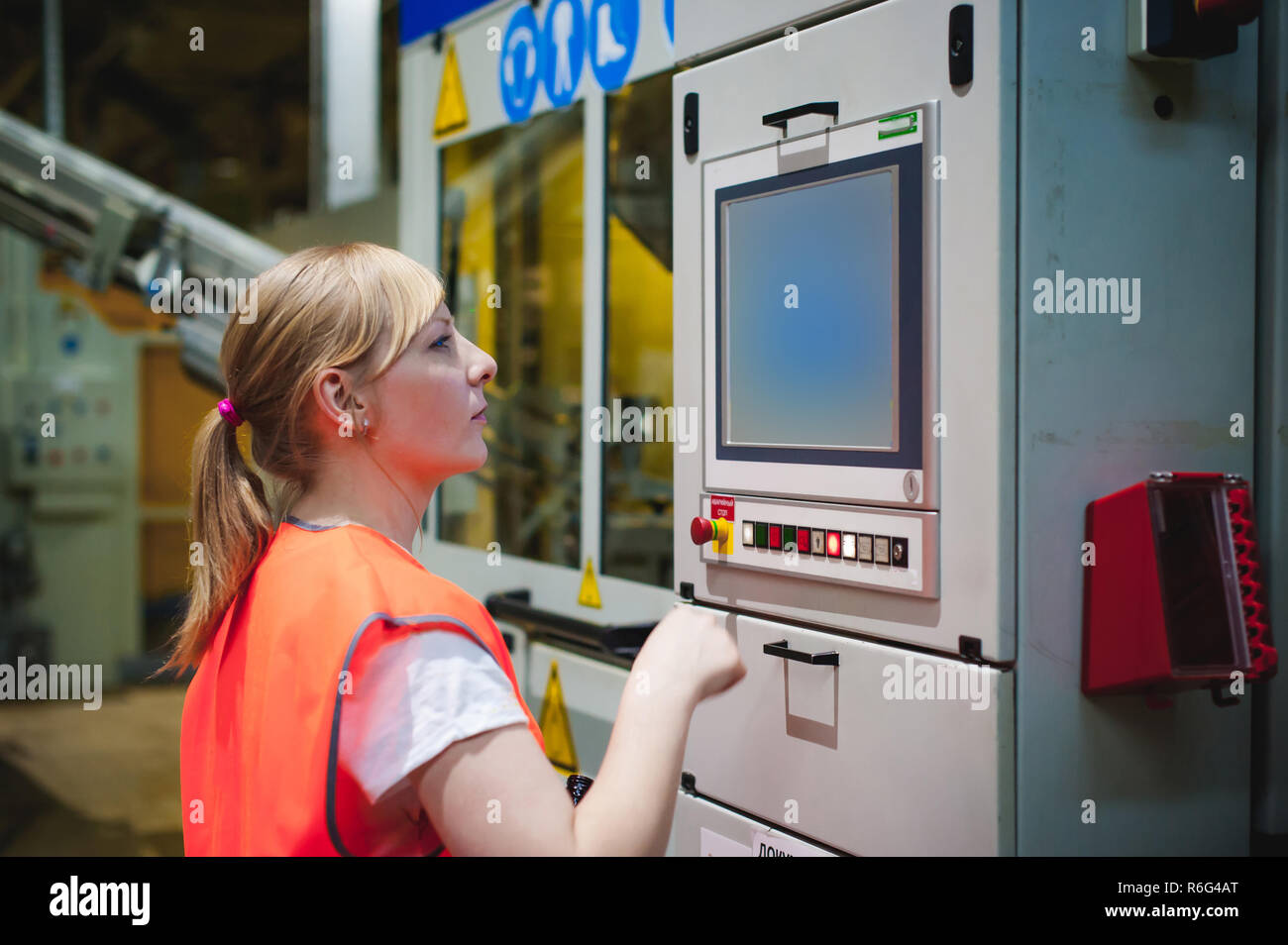 Portrait of a female employee in an orange robe vest in the working ...