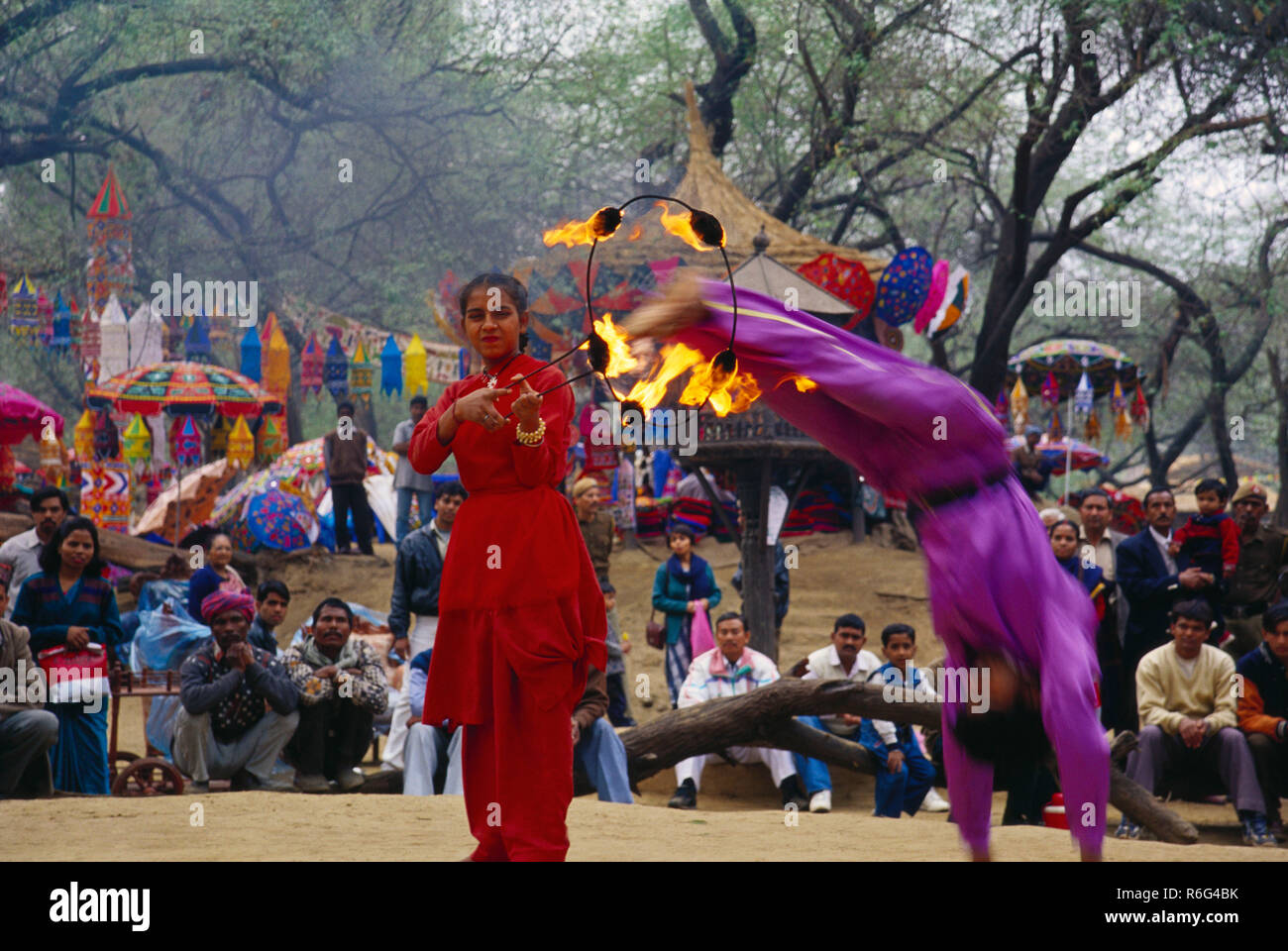 Woman jumping through fire hoop, Surajkund Fair, Faridabad, Haryana, India, Asia Stock Photo