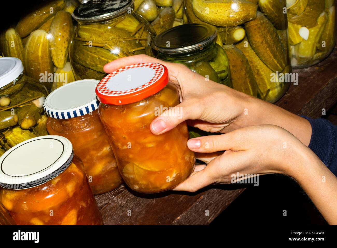 Woman puts jam jars in the basement, for storage for a long time Stock