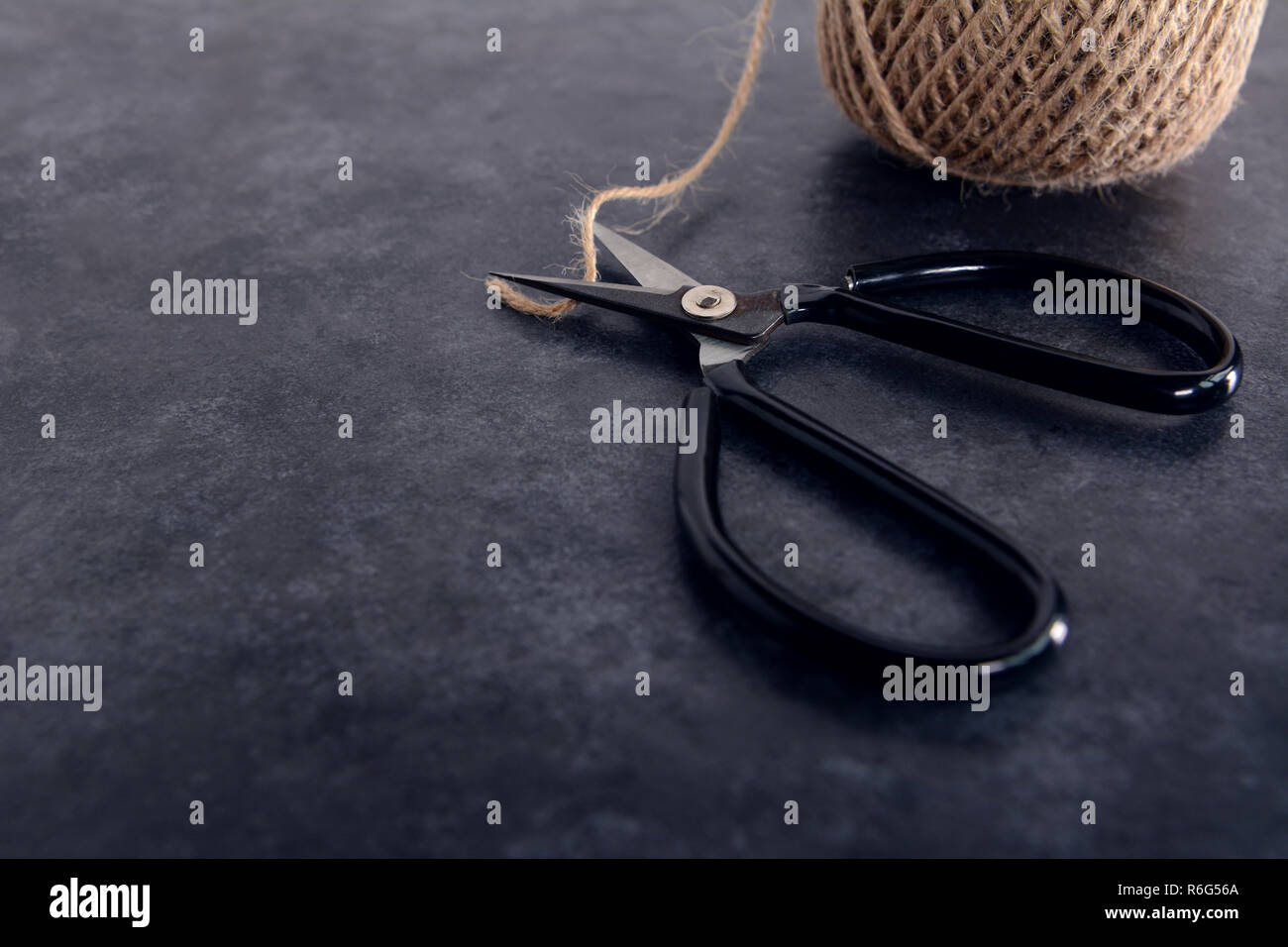 Oldfashioned scissors cutting piece of garden twine Stock Photo Alamy