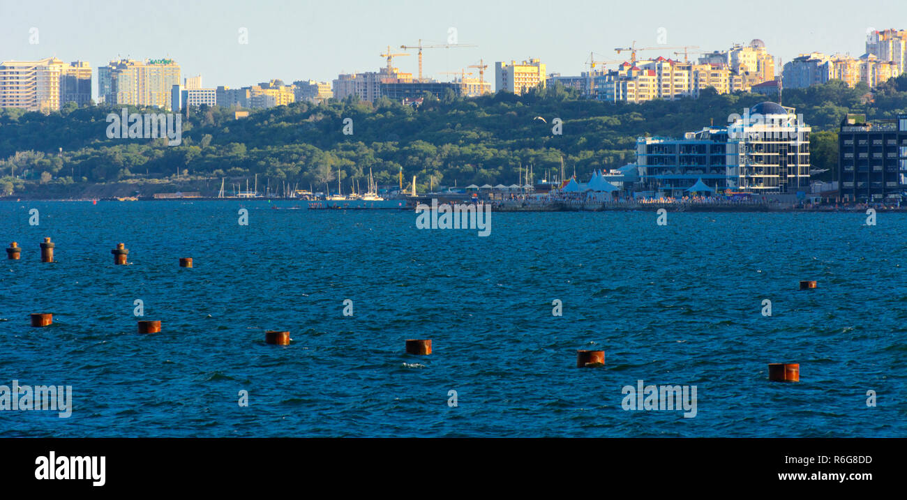 Magnificent panorama, view from the sea to the coastal strip of the city before sunset in the soft sunlight. High-rise buildings and commercial facili Stock Photo