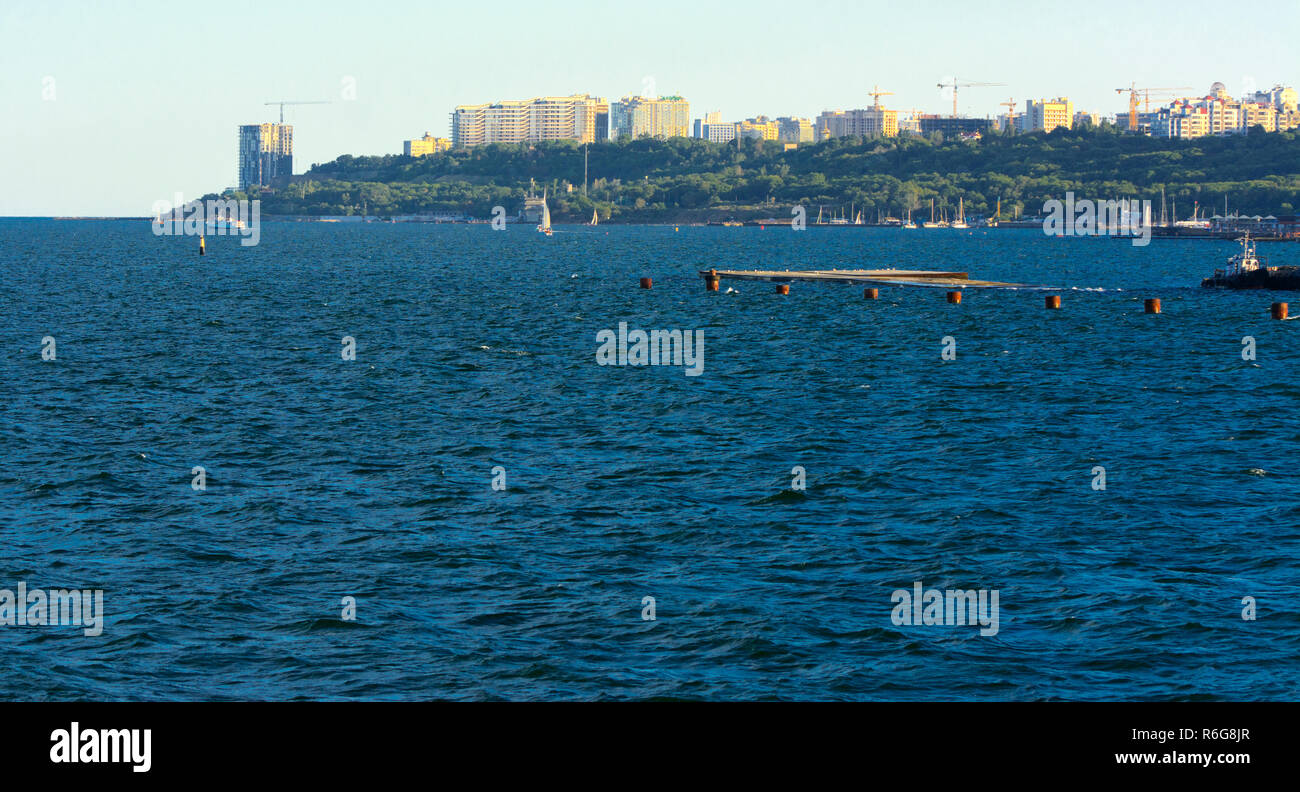 Magnificent panorama, view from the sea to the coastal strip of the city before sunset in the soft sunlight. High-rise buildings and commercial facili Stock Photo