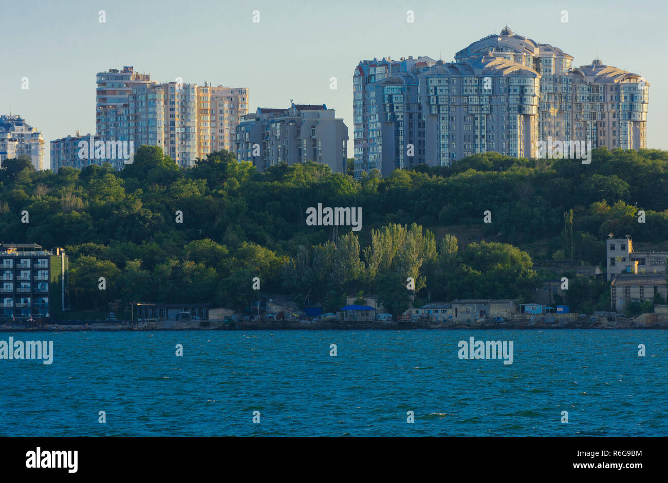 Magnificent panorama, view from the sea to the coastal strip of the city before sunset in the soft sunlight. High-rise buildings and commercial facili Stock Photo