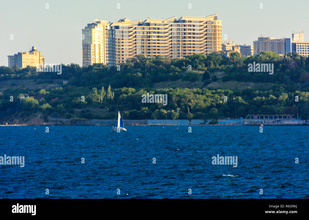 Magnificent panorama, view from the sea to the coastal strip of the city before sunset in the soft sunlight. High-rise buildings and commercial facili Stock Photo