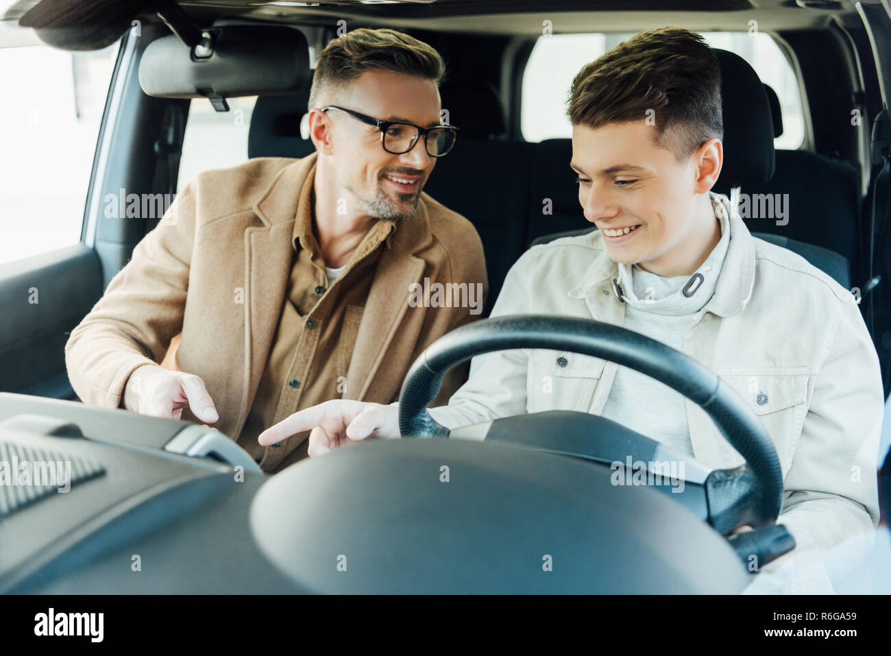 smiling handsome father teaching teen son driving car Stock Photo Alamy