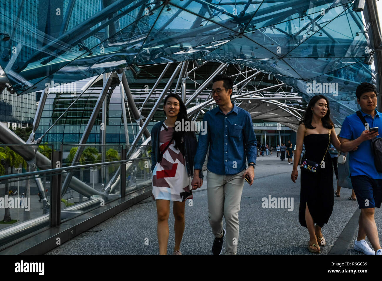 A couple hold hands outside of Marina Bay in Singapore Stock Photo