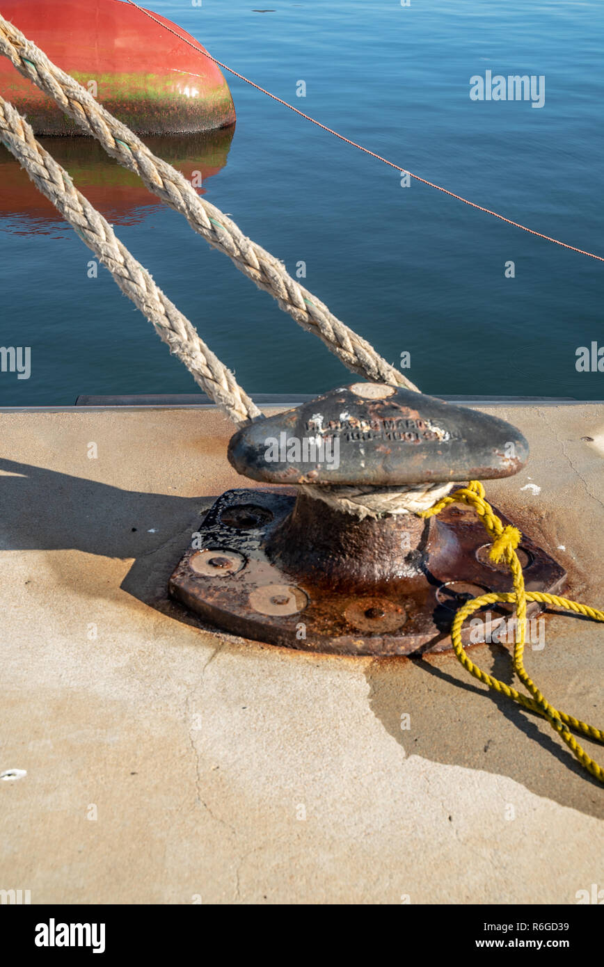 Ferry rope tied to metal boat slip at dock Stock Photo