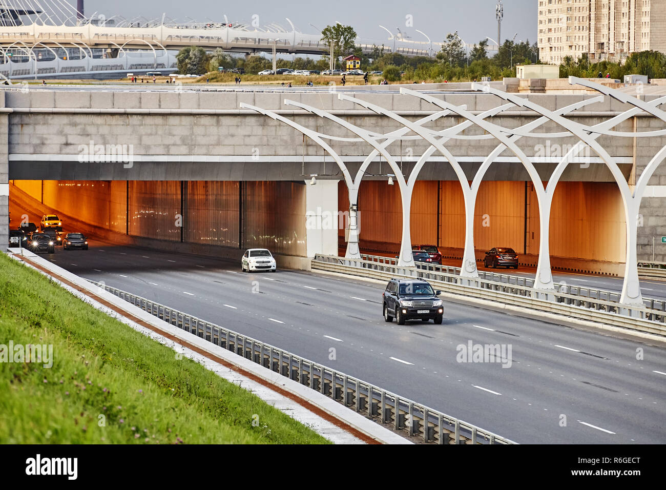 St. Petersburg, Russia - August 24, 2018: Cars leave the tunnel on the freeway with road safety barrier, Saint Petersburg. Stock Photo