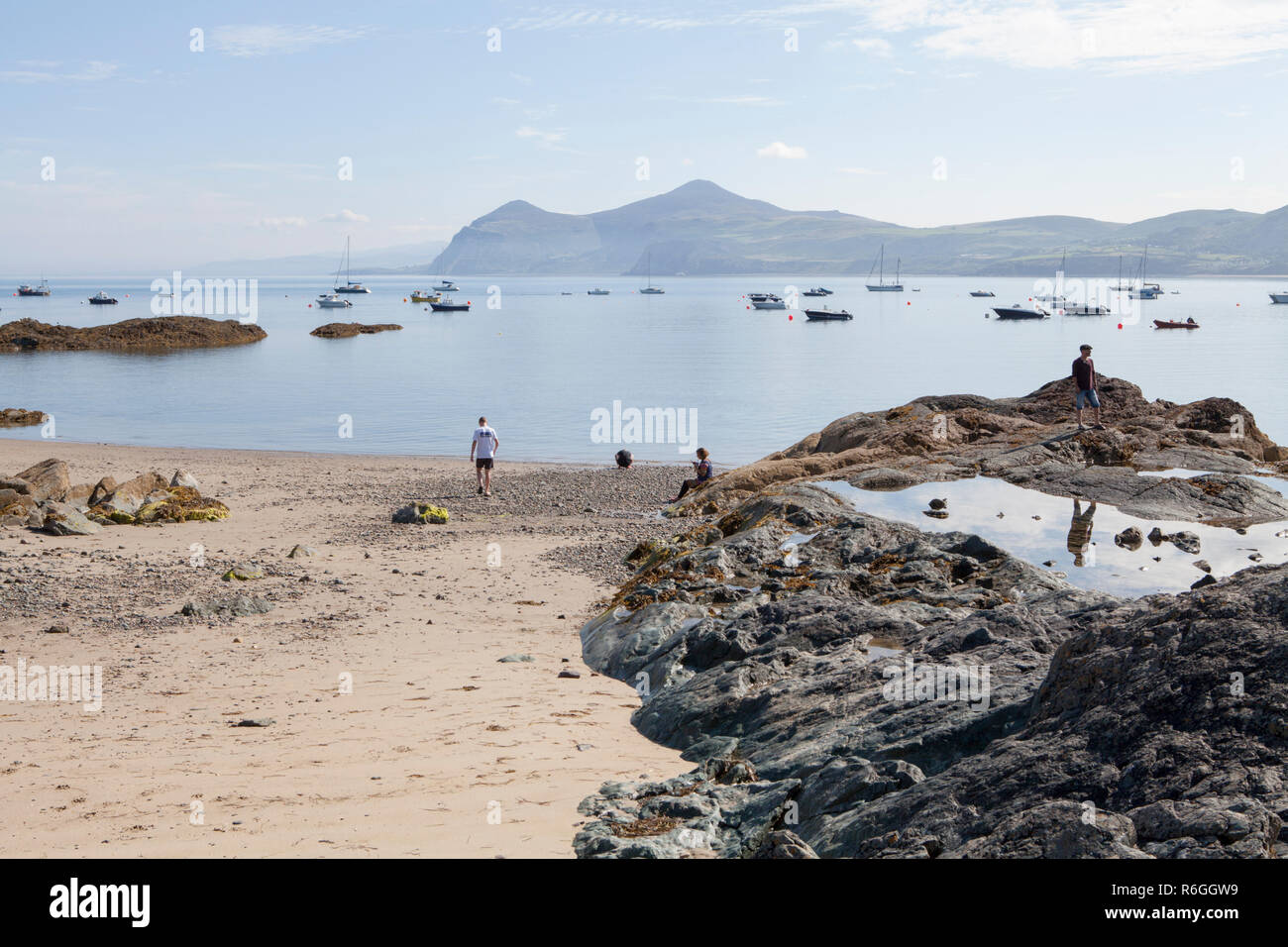Visitors explore the tide line at Morfa Nefyn beach on the Llyn Peninsula in Wales Stock Photo