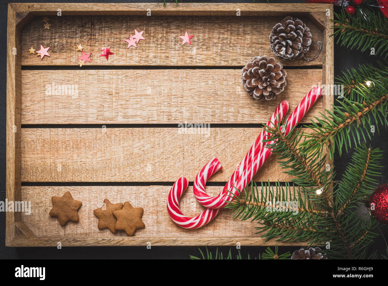 Wooden background with candy canes, fir tree, cones. Christmas or New Year background with copy space for text. Gift card, greeting card, design templ Stock Photo