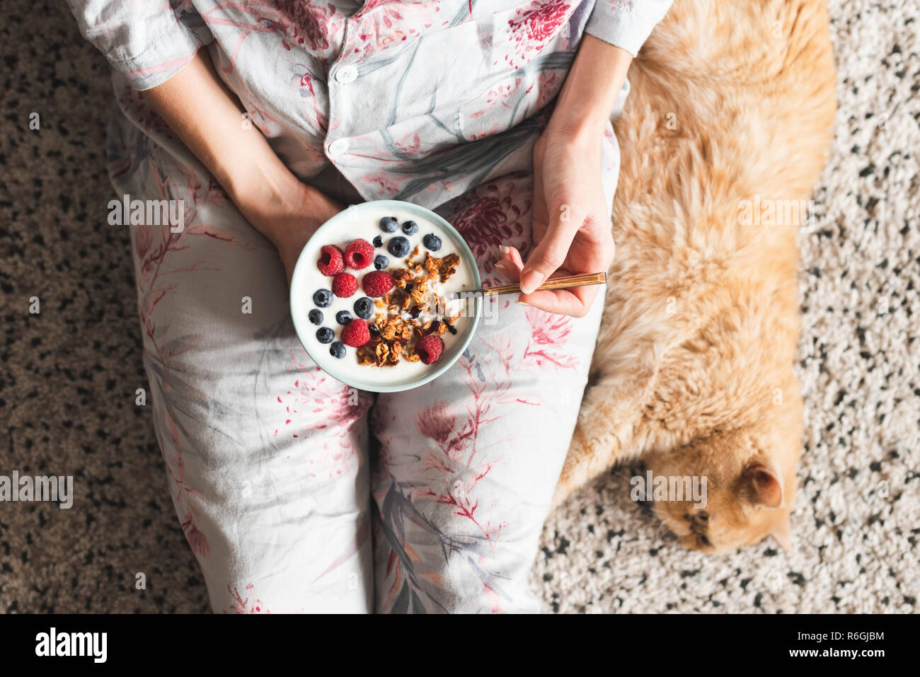Girl eating healthy breakfast bowl with yogurt and berries. Vegetarian diet breakfat. Top view Stock Photo
