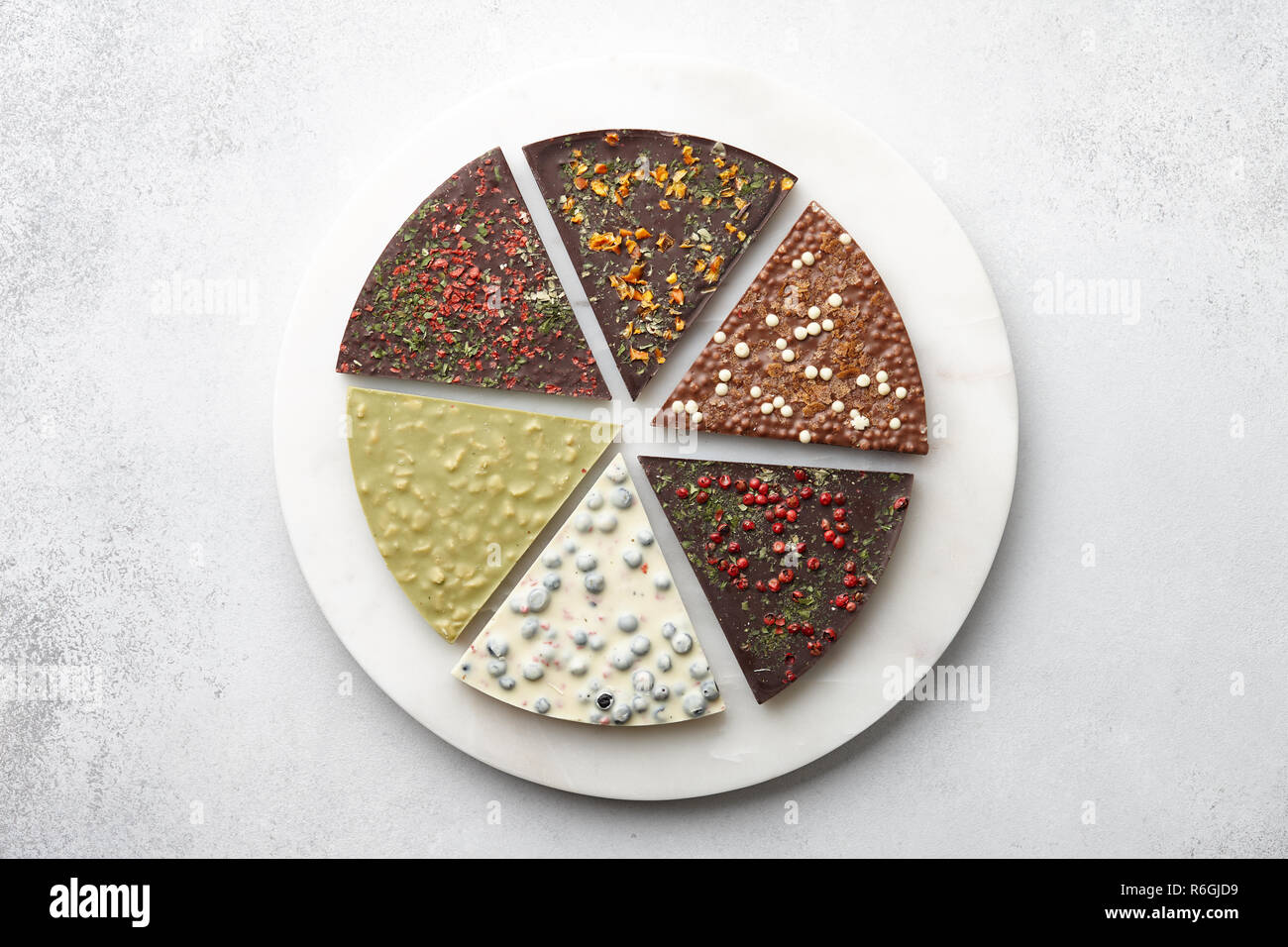 Round chocolate pizza pieces on white textured background Stock Photo
