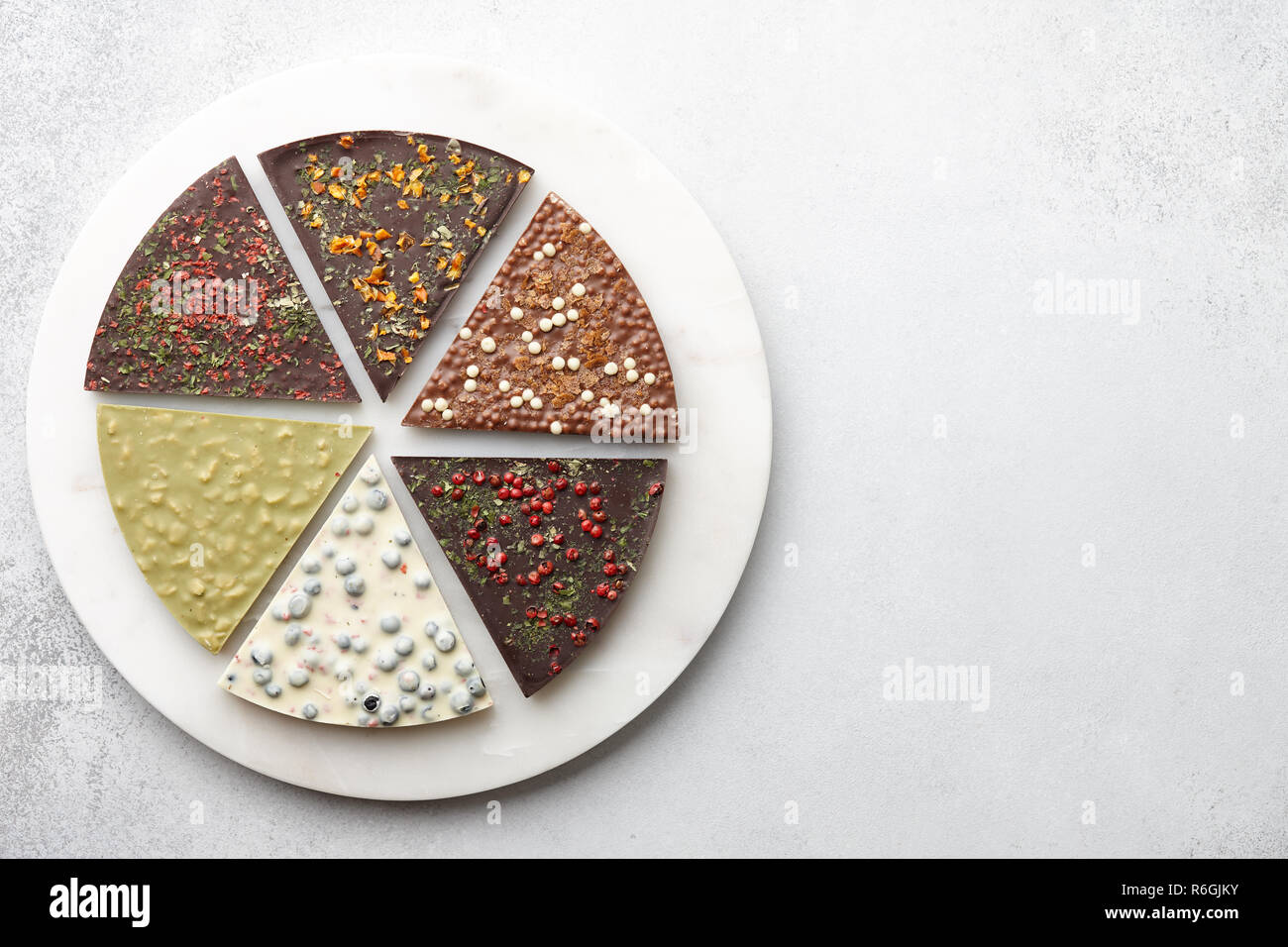 Round chocolate pizza pieces on white textured background Stock Photo
