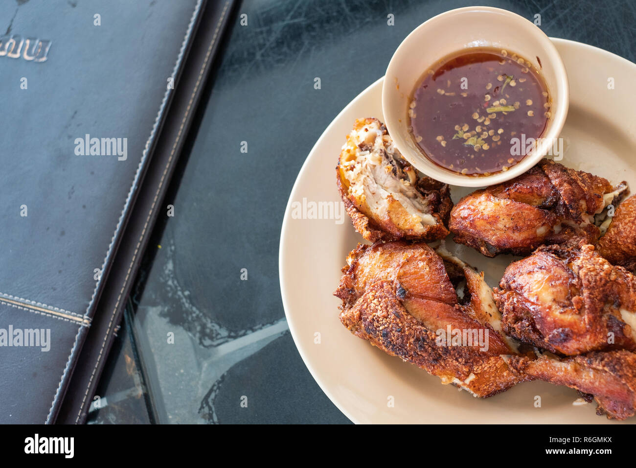 Fried chicken with spicy source in Thai menu style is served ready to be eaten. Stock Photo