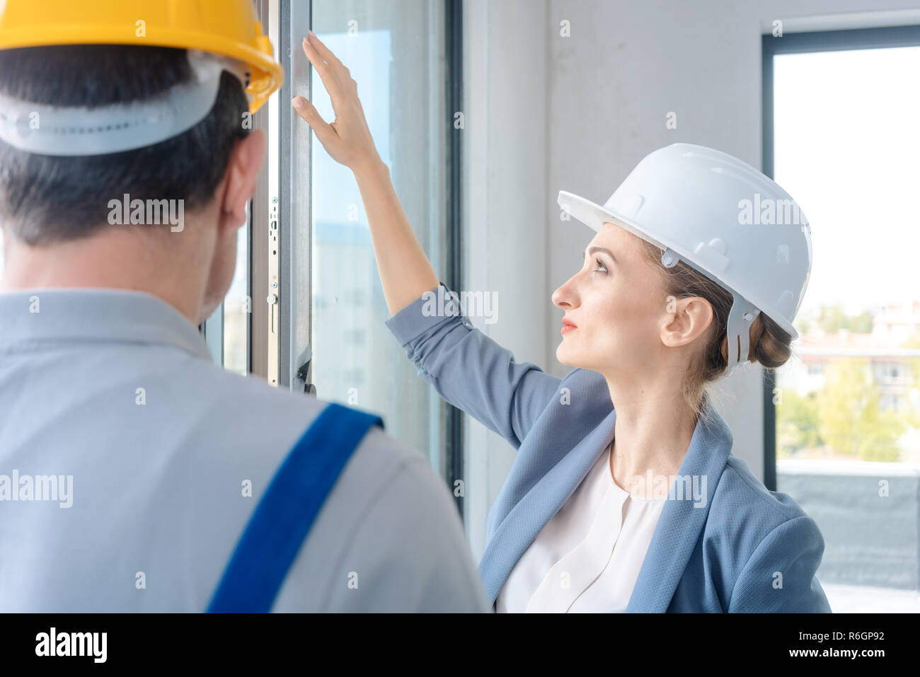 Architect and construction worker checking windows on site Stock Photo