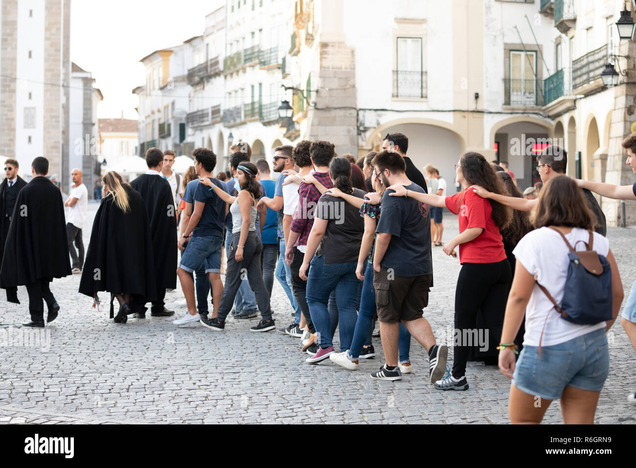 New students with hands on each others shoulders walking through the old town in an induction ceremony, Evora, Alentejo, Portugal, Europe Stock Photo