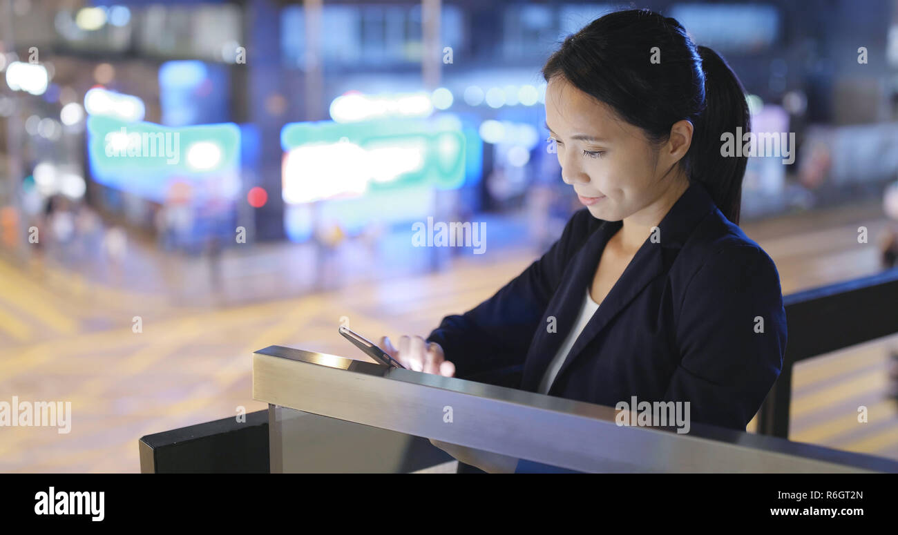 Business woman use of smart phone in city at night Stock Photo - Alamy