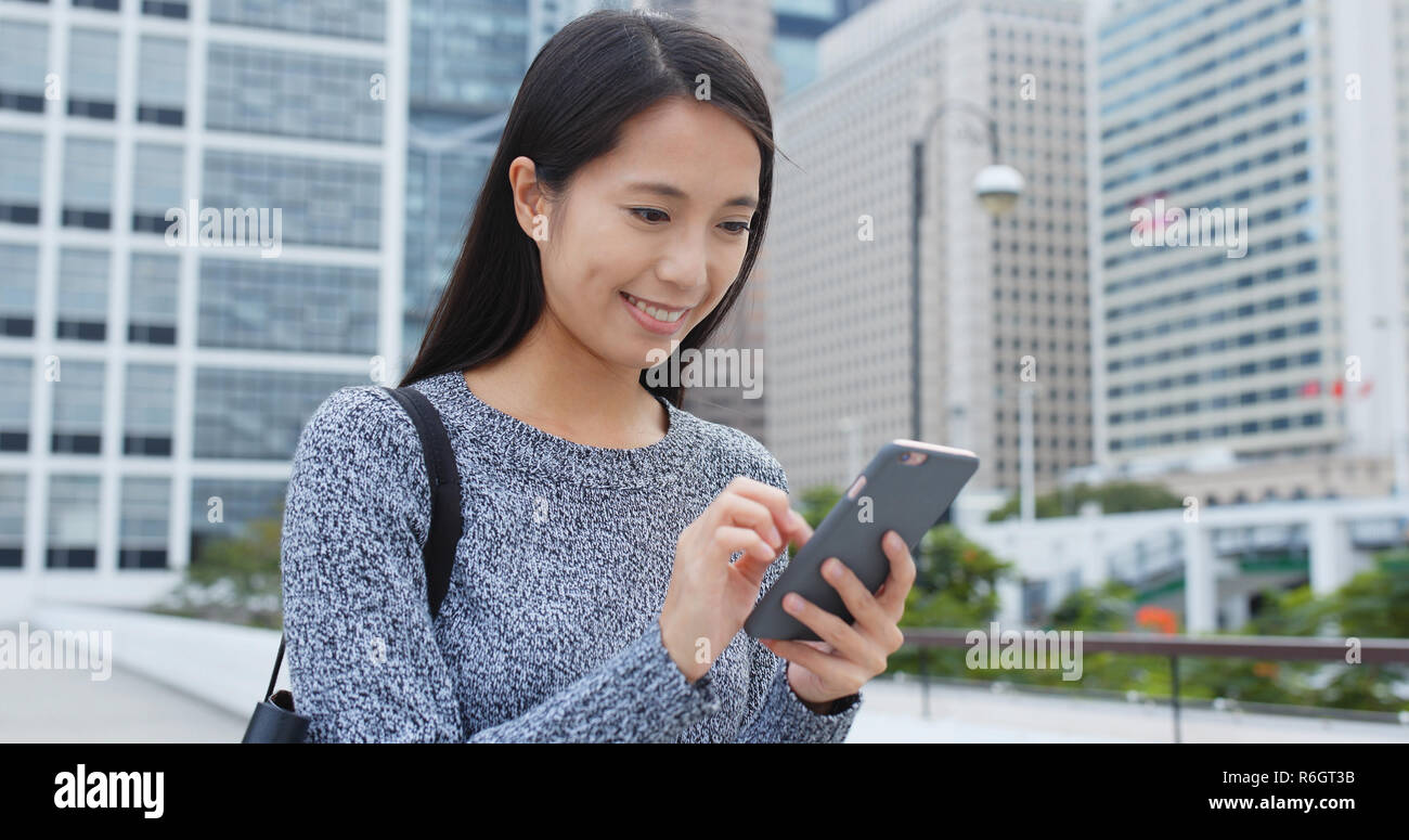 Woman look at mobile phone city Stock Photo - Alamy