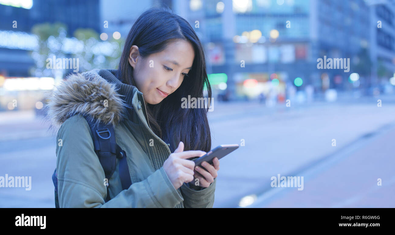 Young woman use of mobile phone in the city at night Stock Photo - Alamy