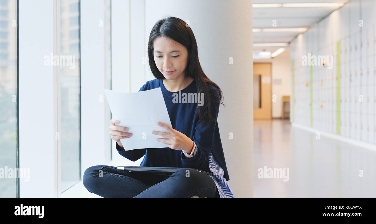 Woman reading on paper note in university campus Stock Photo