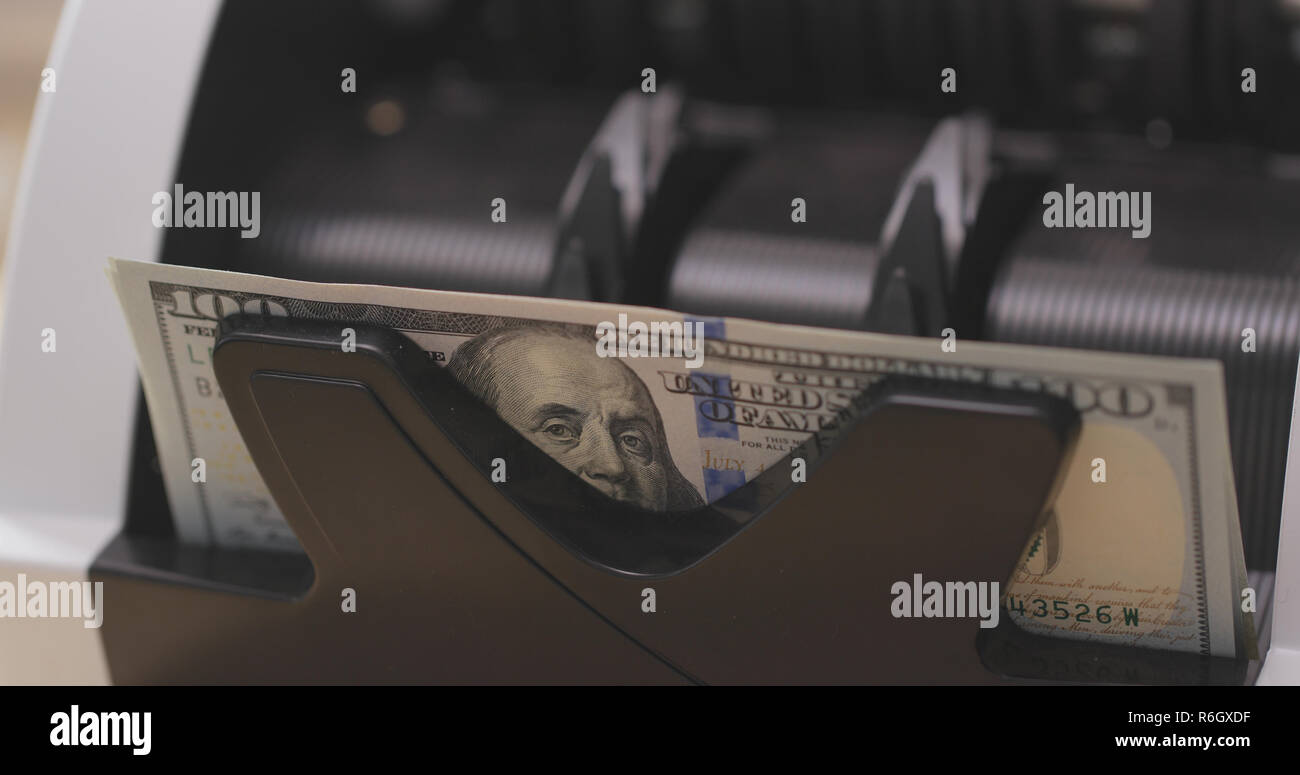 Money counter is counting paper money of American dollars Stock Photo