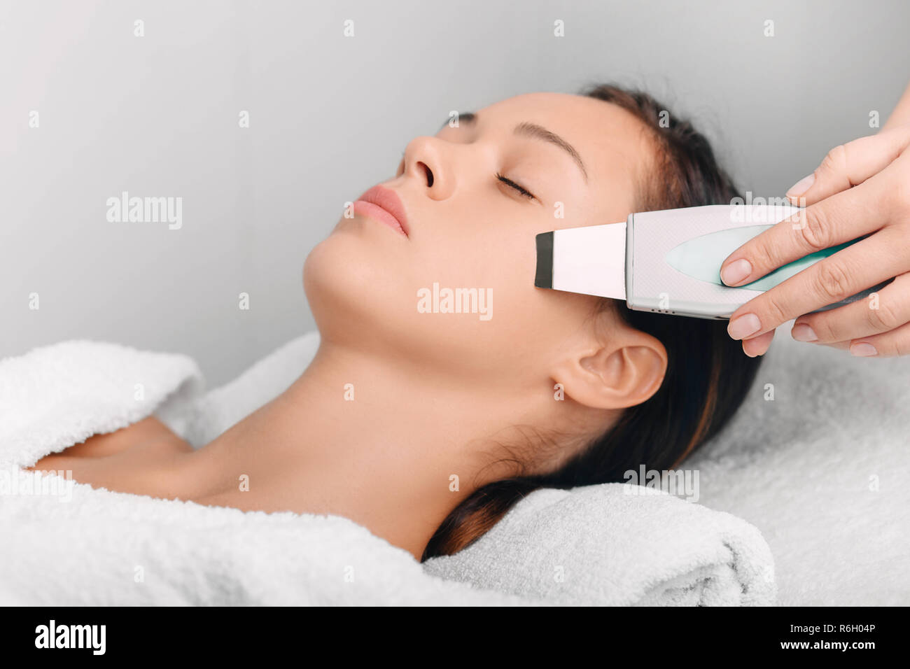 Beautiful woman receiving ultrasound skin cleaning, facial peeling. Cosmetology and facial skin care Stock Photo