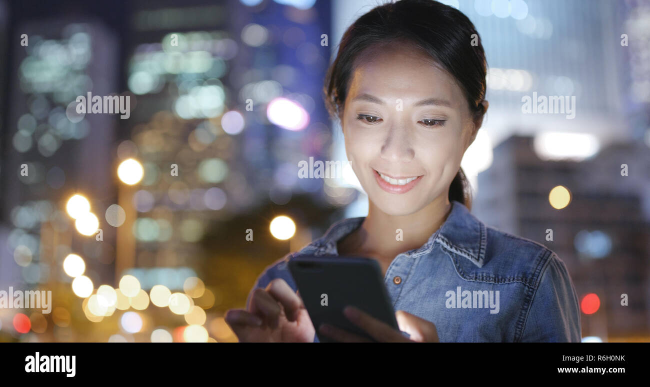 Woman using mobile phone in Hong Kong at night Stock Photo - Alamy