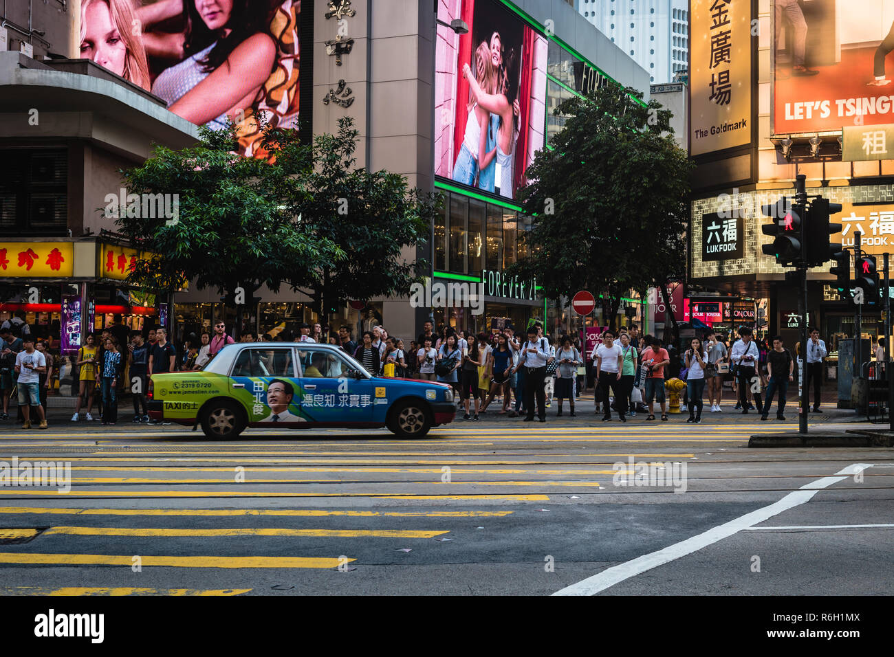 People waiting for a green light so the can cross a street in Hong Kong. Stock Photo