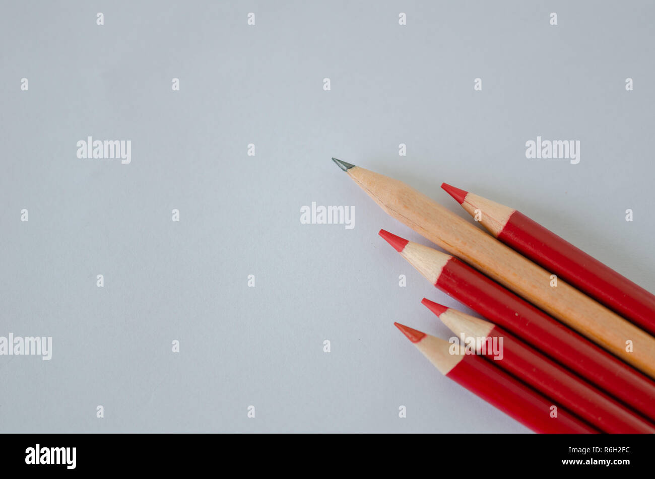 Many group of red pencils but yellow color pencil standing out from crowd of plenty identical, leadership, independence, uniqueness, initiative, initi Stock Photo
