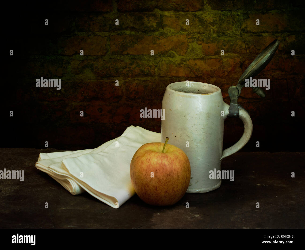 Old fashioned beer mug, tankard with apple and cloths, serviettes aka napkins. Lunch maybe. Still life. Stock Photo