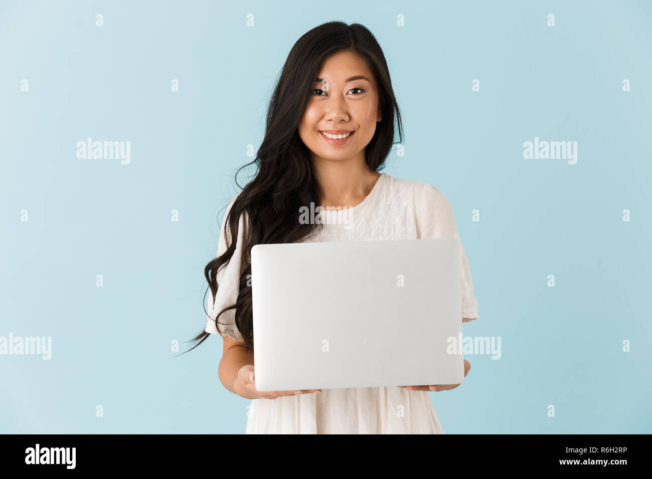 Image of young happy asian beautiful woman isolated over blue ...